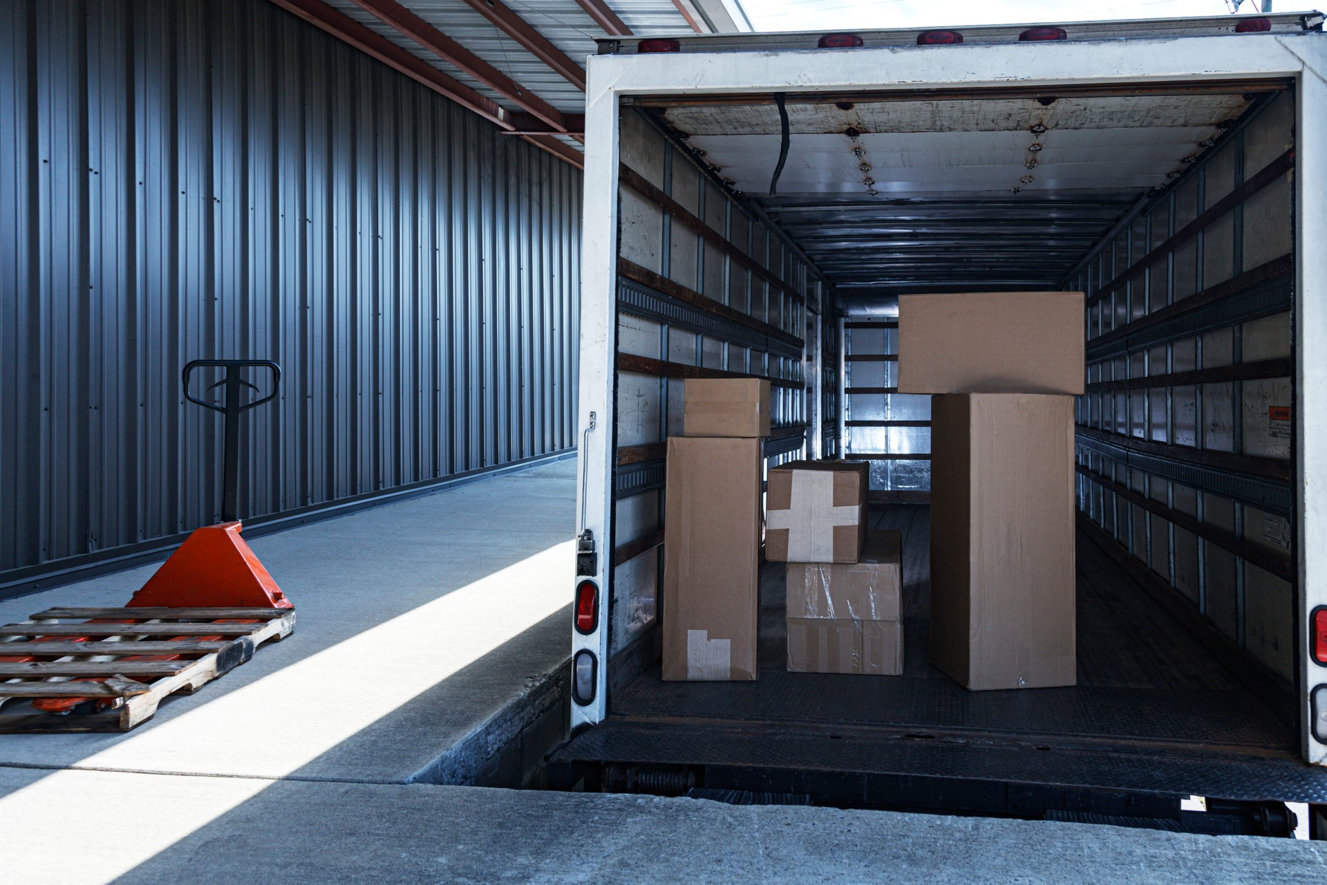 Retail Merchandise Cardboard Boxes Stacked In Open Delivery Truck